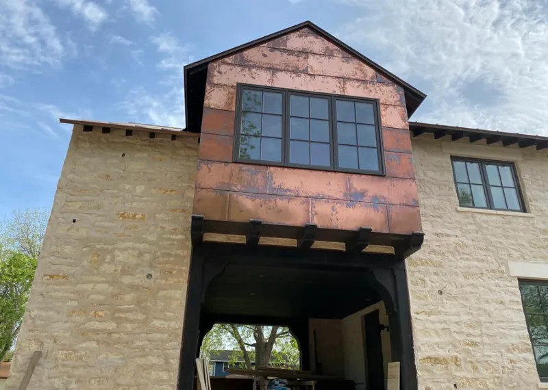 Copper metal panel facade on a stone building for Skylight Installation in Maryville